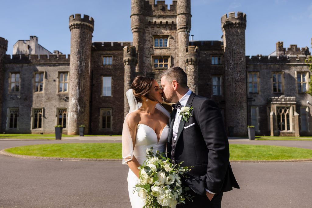 Just married couple kissing outside Hensol Castle